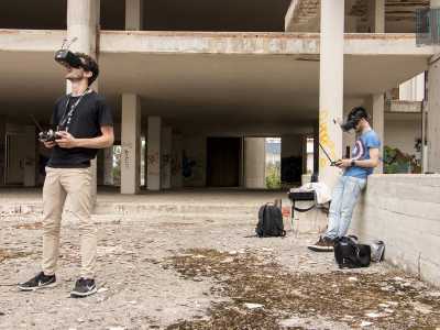 Nell'atrio incontriamo immediatamente due giovani: indossano una visiera e maneggiano un telecomando per far volare i loro droni